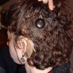 Wearing a CI, hair pulled back